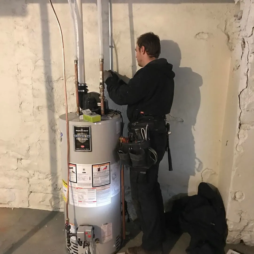 Chris Electric electrician working on a water heater hookup in an older basement