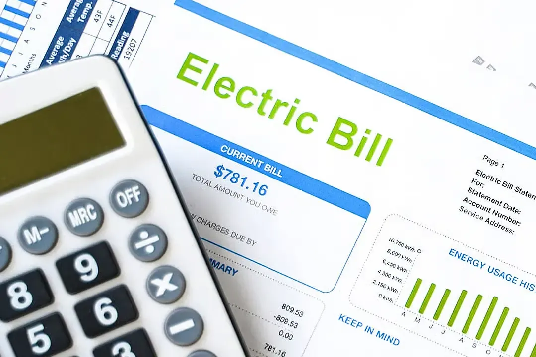 Electric bill statement with an energy usage chart next to a calculator