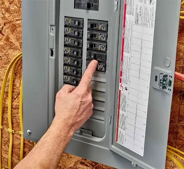 Electrician resetting a circuit breaker in a home breaker panel