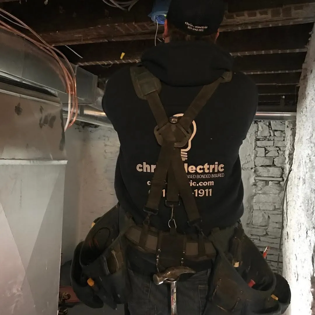 Chris Electric electrician working on wiring in an older basement