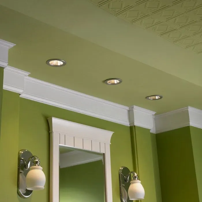 Three recessed lights installed in a bathroom ceiling above a vanity mirror and wall sconces