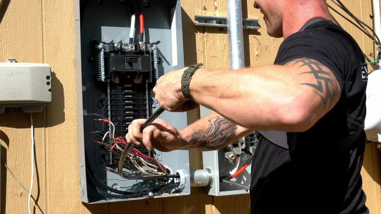 Electrician wiring a new main breaker panel during an electrical panel upgrade